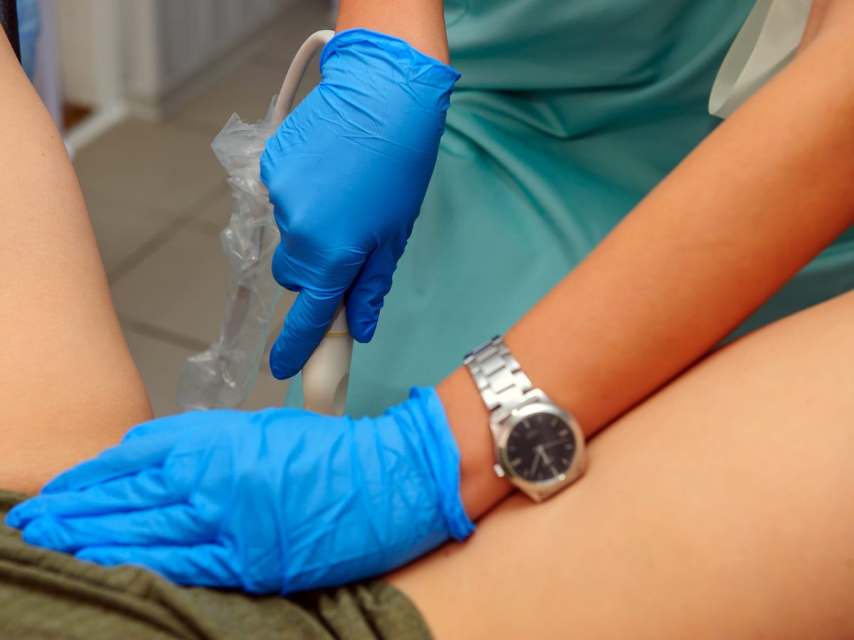 Profissional aplicando implante contraceptivo no braço de paciente